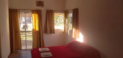 a bedroom with a red bed and a window at El Chinchero Departamentos in Merlo