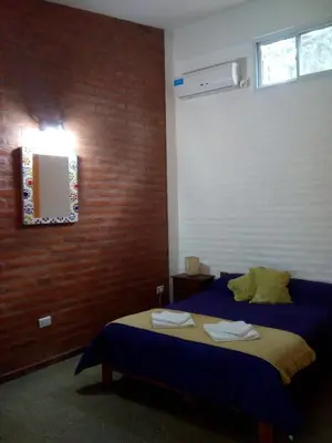 a bedroom with a bed and a mirror and a window at El Chinchero Departamentos in Merlo