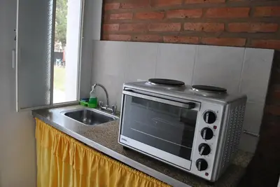 a microwave sitting on a kitchen counter next to a sink at El Chinchero Departamentos in Merlo