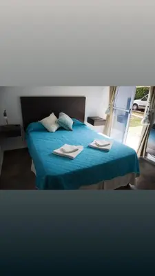 a bedroom with a blue bed with two towels on it at El Chinchero Departamentos in Merlo