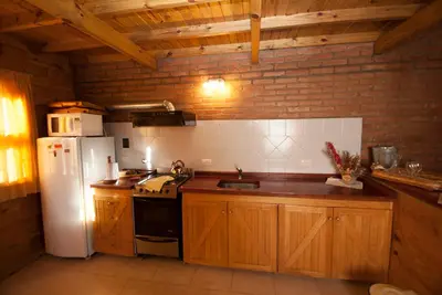 a kitchen with wooden cabinets and a white refrigerator at Rancho Paradise - Adults Only in Nono
