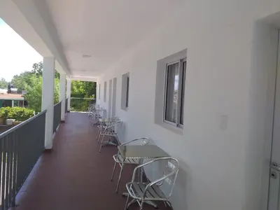 a corridor with chairs and tables on a balcony at Abuela Mari Apart Cabaña in Villa Cura Brochero