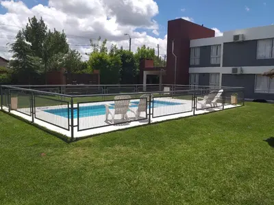 a pool deck with two lawn chairs next to a building at Abuela Mari Apart Cabaña in Villa Cura Brochero