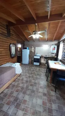 a kitchen and living room with a couch and a table at Hotel y Cabañas Green Park in Nono