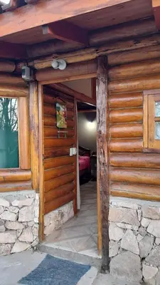 an entrance to a log cabin with a wooden door at Hotel y Cabañas Green Park in Nono