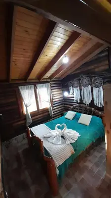 a bedroom with a bed with towels on it at Hotel y Cabañas Green Park in Nono