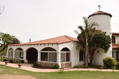 a white house with a tower and a palm tree at Estancia Santa Leocadia in Bialet Massé