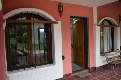 a house with two doors and a bench next to it at Estancia Santa Leocadia in Bialet Massé