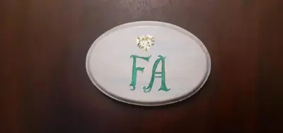 a plate with the letter k with a flower on it at La Posada de Akasha in Villa General Belgrano
