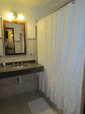 a bathroom with a shower curtain and a sink at La Posada de Akasha in Villa General Belgrano
