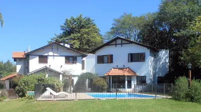 a white house with a pool in front of it at La Posada de Akasha in Villa General Belgrano