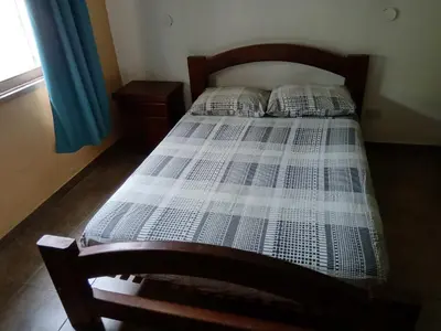 a bedroom with a bed with a wooden head board at Casa Fleming in Villa Carlos Paz