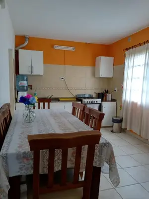 a kitchen with a table and chairs and a kitchen with at Casa Fleming in Villa Carlos Paz