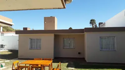 a patio with a table and chairs in front of a house at Casa Fleming in Villa Carlos Paz