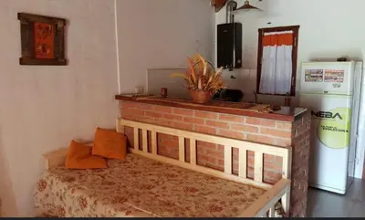 a bed in a room with a brick fireplace at Cabañas Tia Elmira in Villa Cura Brochero