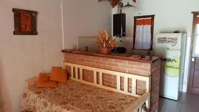 a room with a brick fireplace and a bed in it at Cabañas Tia Elmira in Villa Cura Brochero