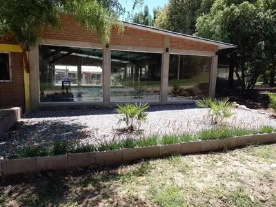 a screened in porch of a building with plants at Complejo Los Gringos in Villa Ciudad de America