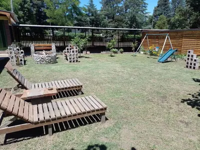 a playground with wooden benches and a swing at Complejo Los Gringos in Villa Ciudad de America