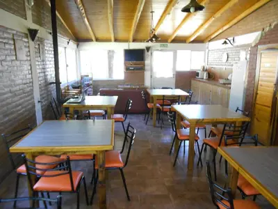a restaurant with tables and chairs in a room at Complejo Los Gringos in Villa Ciudad de America