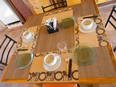 a wooden table with cups and saucers on it at Complejo Los Gringos in Villa Ciudad de America