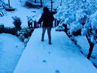 a person walking down a path in the snow at Cielo de Piedra. Cabañas y Petit Hotel in Tanti