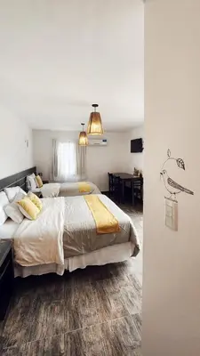 a bedroom with a large bed and a dining room at Posada Piedramora in Mina Clavero