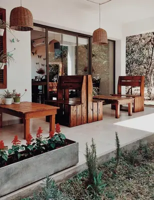 a patio with two wooden tables and benches at Posada Piedramora in Mina Clavero