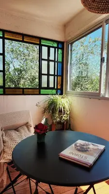 a table with a book on it in a room with windows at Posada Piedramora in Mina Clavero