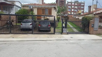 two cars parked in front of a black gate at complejo Casa Walter in Villa Carlos Paz
