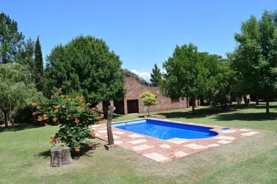 a swimming pool in the yard of a house at Cabañas La Rosada in Santa Rosa de Calamuchita