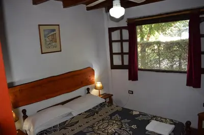 a bedroom with a bed and a window at Cabañas La Rosada in Santa Rosa de Calamuchita