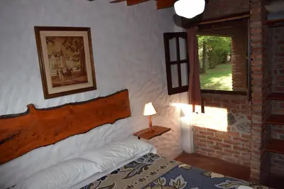 a bedroom with a bed and a window at Cabañas La Rosada in Santa Rosa de Calamuchita