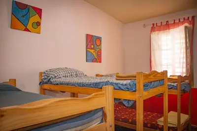 a bedroom with two bunk beds and a window at El Viaje Hostel in Mina Clavero