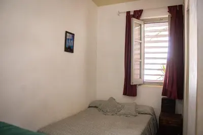 a small bedroom with a bed and a window at El Viaje Hostel in Mina Clavero