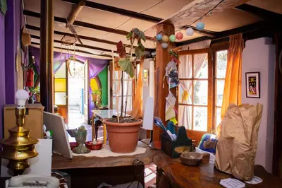 a living room with a table and some windows at El Viaje Hostel in Mina Clavero