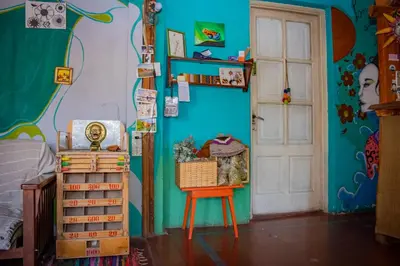 a bedroom with a blue wall and a chair and a door at El Viaje Hostel in Mina Clavero