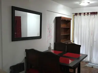 a dining room with a table and a mirror on the wall at Departamento en Nueva Cordoba in Cordoba