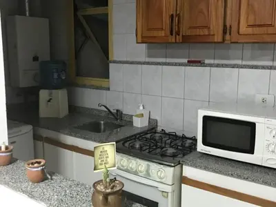 a kitchen with a stove and a microwave at Departamento en Nueva Cordoba in Cordoba
