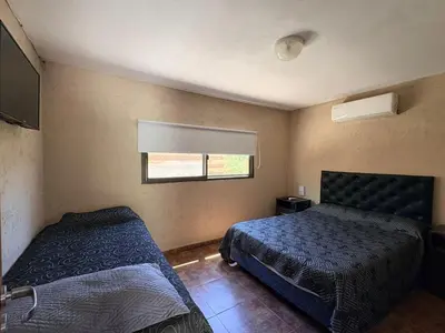a bedroom with two beds and a window at Los Frutales in Villa Carlos Paz