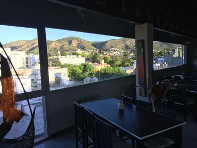 a dining room with a table and a view of the city at Aires de la Villa in Villa Carlos Paz