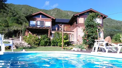 a house with a swimming pool in front of a house at Balcon Al Paradiso in Santa Rosa de Calamuchita