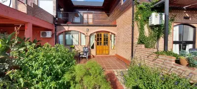 a brick house with a yellow door and a patio at Balcon Al Paradiso in Santa Rosa de Calamuchita