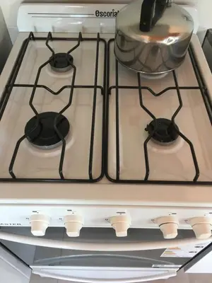 a stove top oven with a pot on top of it at La Carolina in Santa Rosa de Calamuchita