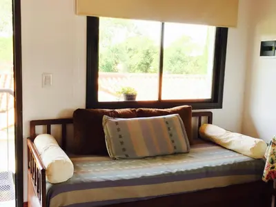 a bench in a room with a window and pillows at La Carolina in Santa Rosa de Calamuchita