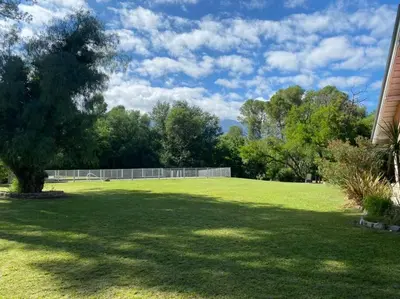 a large lawn with a tree in the middle at Los Oleandros - casa privada in Nono