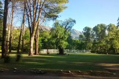 a park with trees and grass and mountains in the background at Los Oleandros - casa privada in Nono
