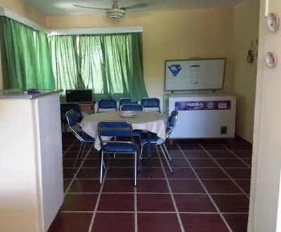 a room with a table and chairs and a screen at Los Oleandros - casa privada in Nono