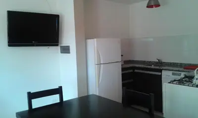 a kitchen with a black table and a white refrigerator at Aires de la Villa II in Villa Carlos Paz