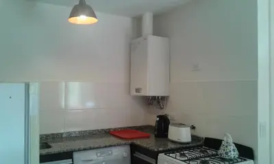 a kitchen with a stove and a counter top at Aires de la Villa II in Villa Carlos Paz
