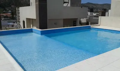 a large blue swimming pool on top of a building at Aires de la Villa II in Villa Carlos Paz